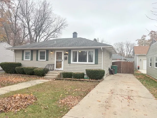 a front view of a house with a yard and potted plants