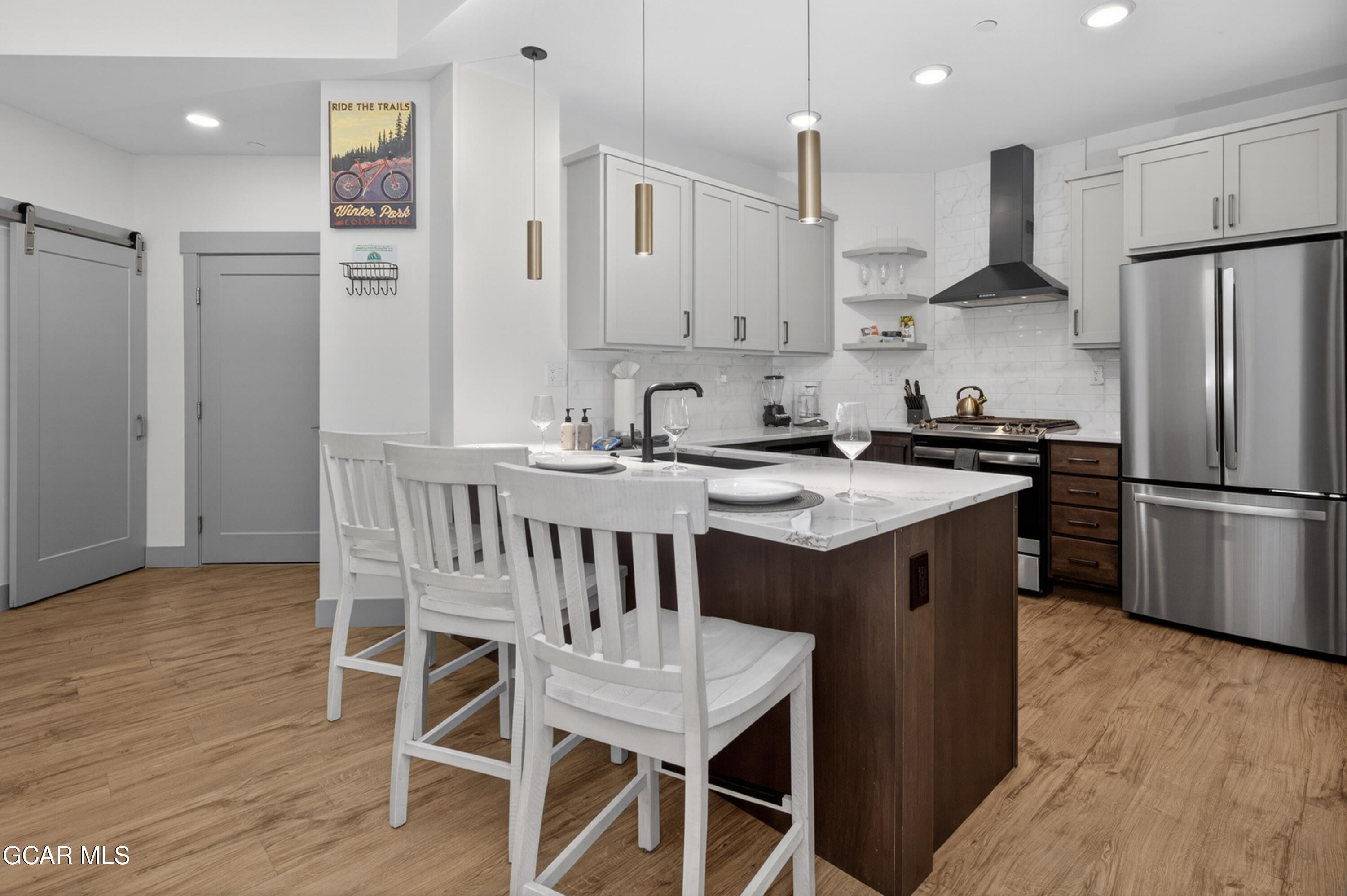 144 Ski Idlewild Road, Unit 2404 Winter Park, CO 80482 - Photo 7 of 43 a kitchen that has a table chairs stainless steel appliances and wooden floor