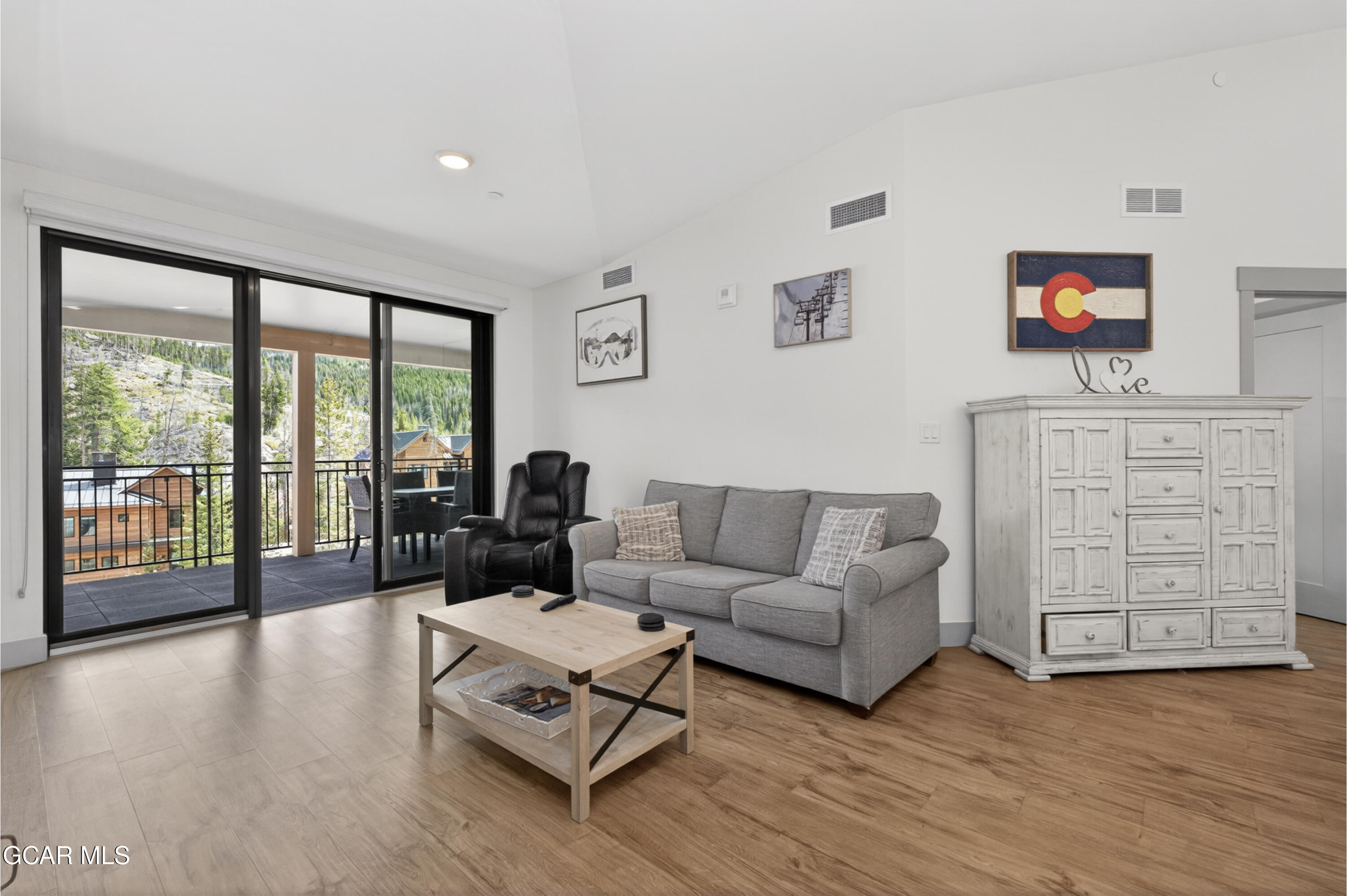 144 Ski Idlewild Road, Unit 2404 Winter Park, CO 80482 - Photo 10 of 43 a living room with furniture a flat screen tv and a floor to ceiling window