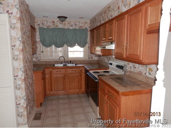 4460 Ruby Road Fayetteville, NC 28311 - Photo 4 of 11 a kitchen with stainless steel appliances granite countertop a stove a sink and a microwave
