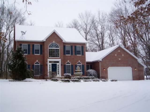 a front view of a house with a yard covered in snow