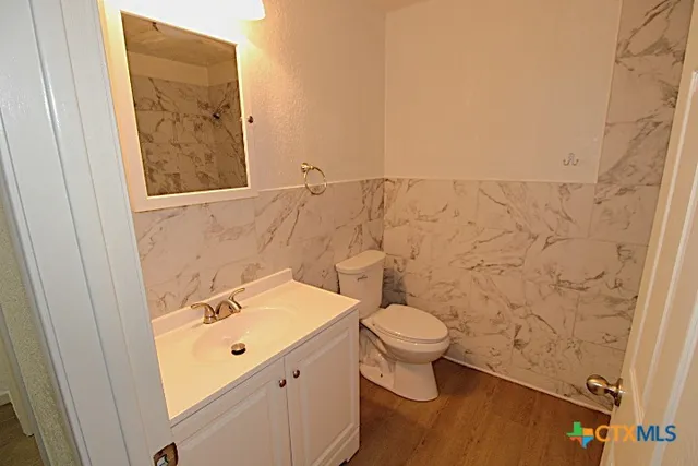 a bathroom with a toilet sink and mirror