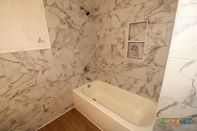 a bathroom with a bathtub and shower