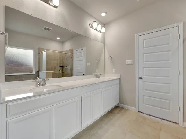 a bathroom with a double vanity sink and a mirror