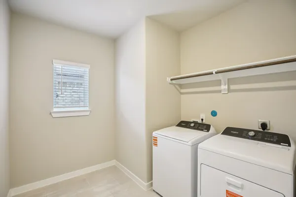 an empty room with a window and a kitchen