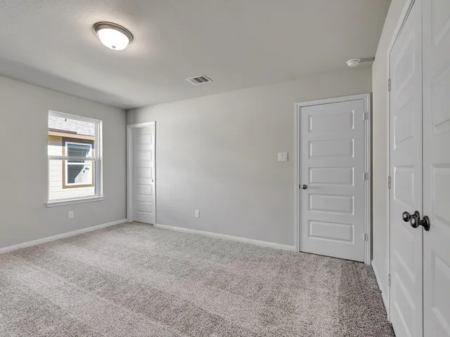 an empty room with windows and closet