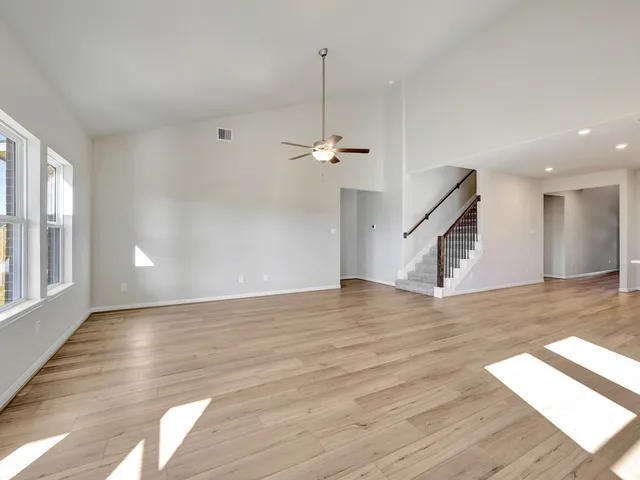 a view of a livingroom with wooden floor and a ceiling fan
