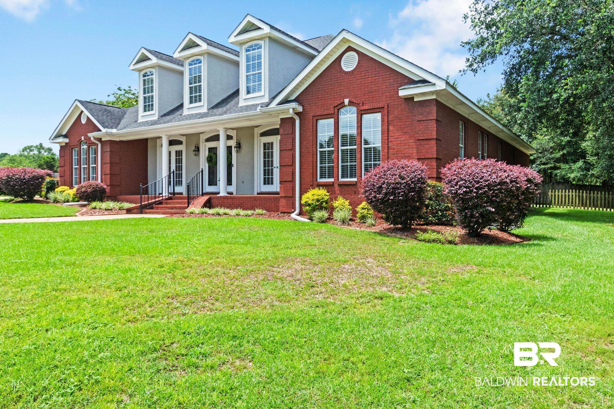 3176 Cedar Court Mobile, AL 36619 - Photo 3 of 33 Brick exterior with dormer windows and a covered front porch featuring white columns and a black railing