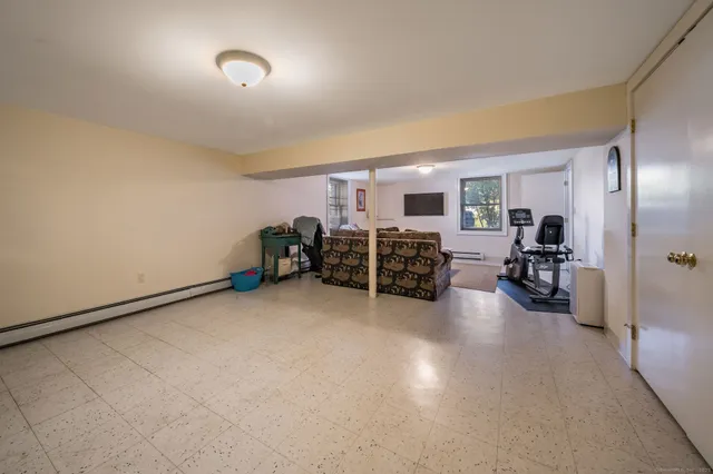 a living room with furniture a flat screen tv and a window