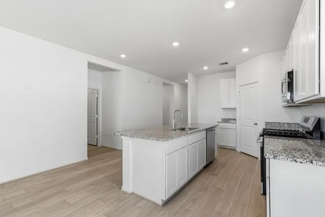 a kitchen with stainless steel appliances granite countertop a sink stove and refrigerator