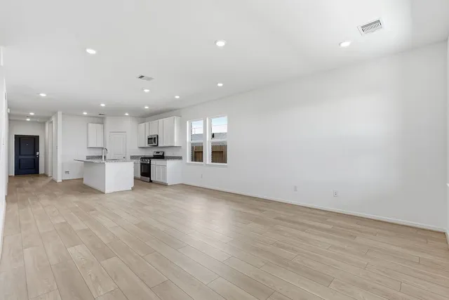 a view of kitchen with kitchen island wooden floor center island and stainless steel appliances