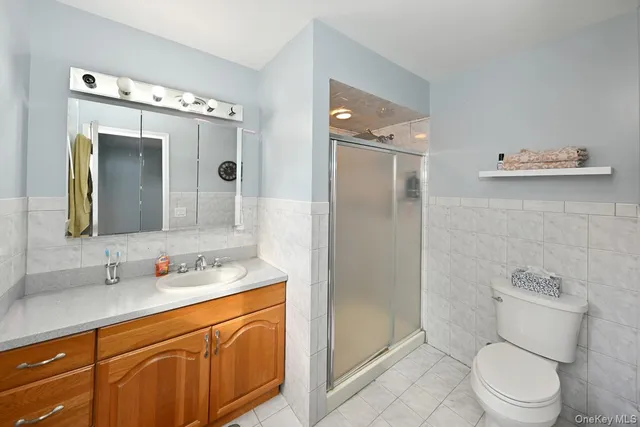 a spacious bathroom with a granite countertop sink toilet mirror and shower
