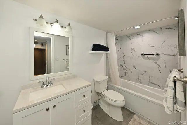 a bathroom with a granite countertop sink a toilet and shower