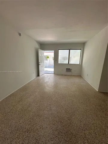 an empty room with windows and fireplace