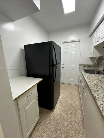 a kitchen with a refrigerator and a sink