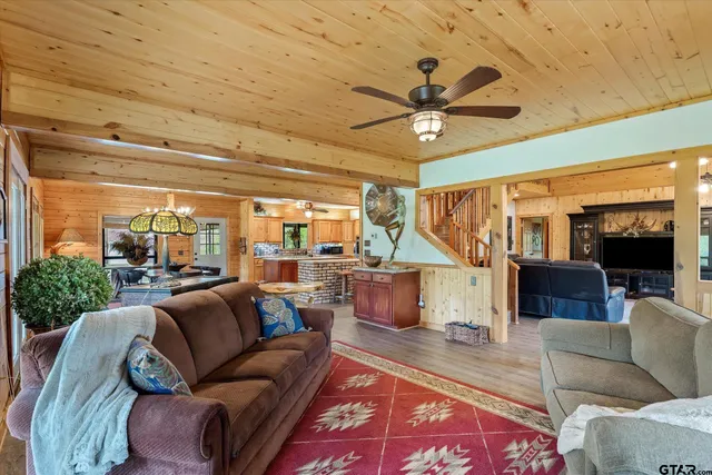 a living room with furniture a ceiling fan and a rug