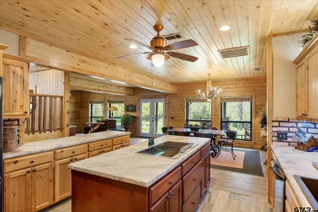 a large kitchen with kitchen island a stove a sink a dining table and chairs