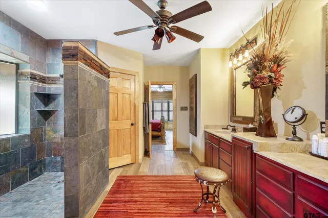 a spacious bathroom with a granite countertop sink a mirror and shower