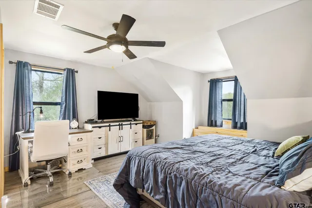 a bedroom with a bed and a flat screen tv