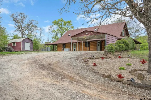 a white house with a large tree in the background