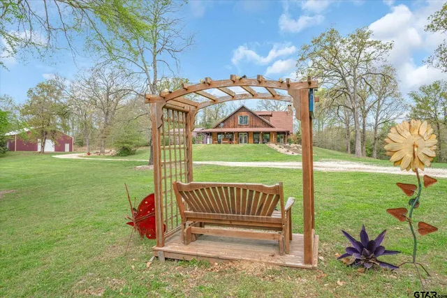 a view of a deck with a big yard potted plants and large tree