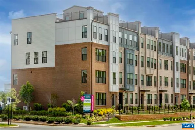 a front view of a building with a yard and plants