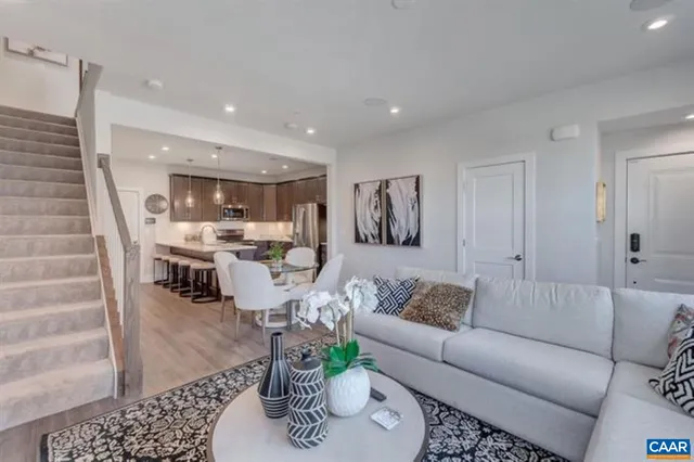 a living room with furniture and a view of kitchen
