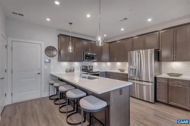 a kitchen with a table chairs refrigerator and microwave