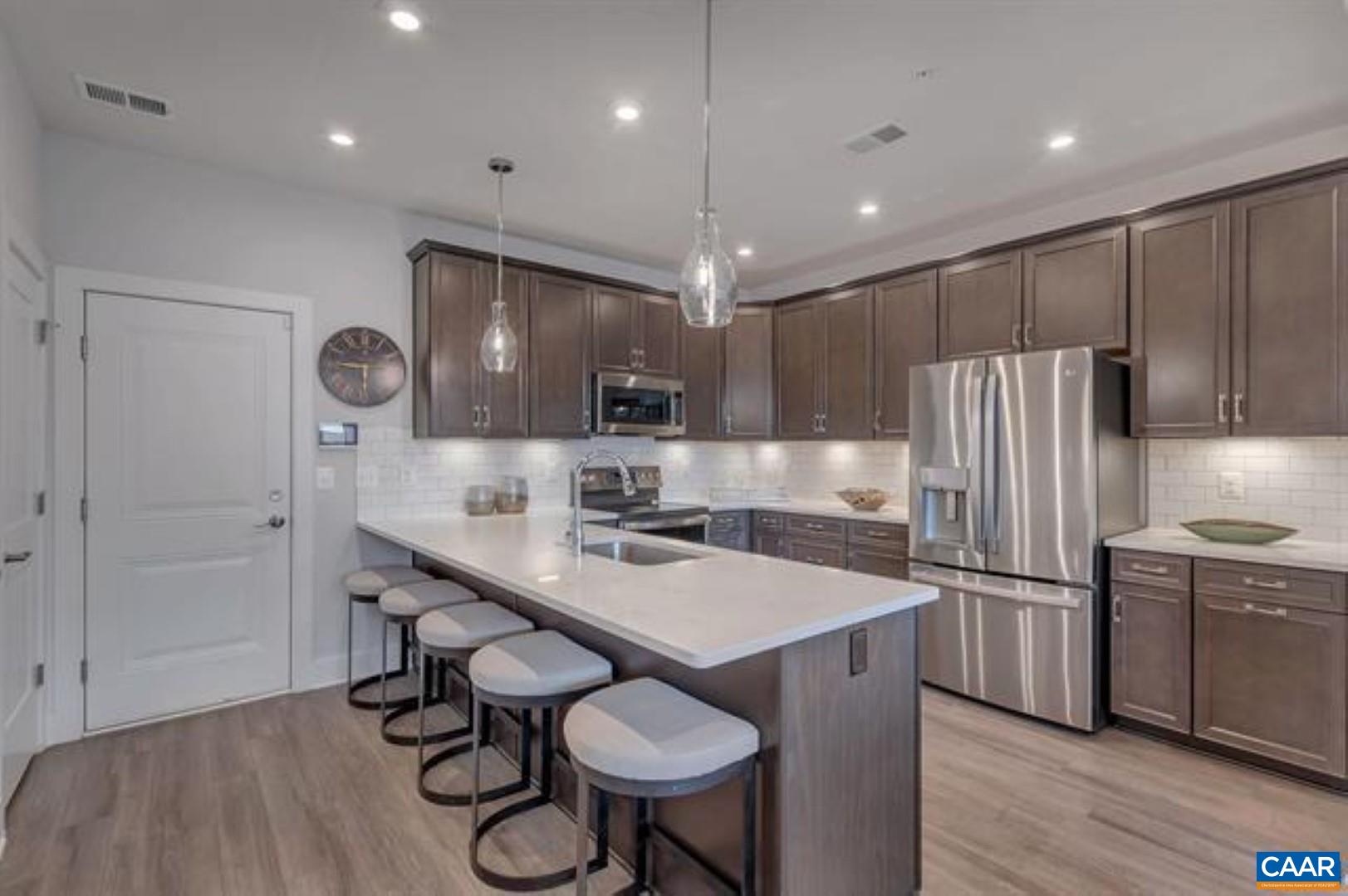 828 A Wesley Lane, Unit A Charlottesville, VA 22911 - Photo 14 of 33 a kitchen with a table chairs refrigerator and microwave