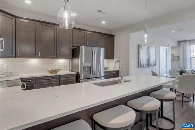 a kitchen with stainless steel appliances a sink a table and chairs