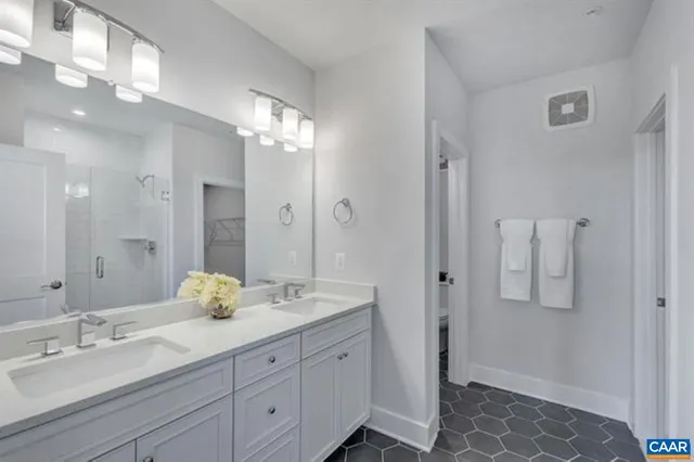 a spacious bathroom with a double vanity sink shower and mirror