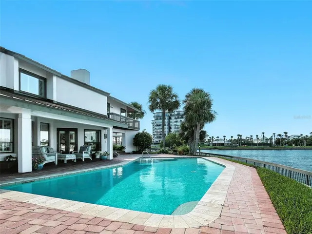 a front view of a house with a garden and palm trees
