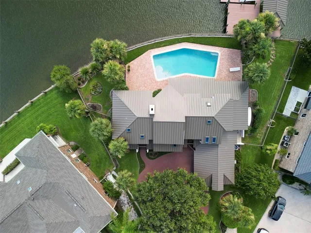 an aerial view of a house with a garden and lake view