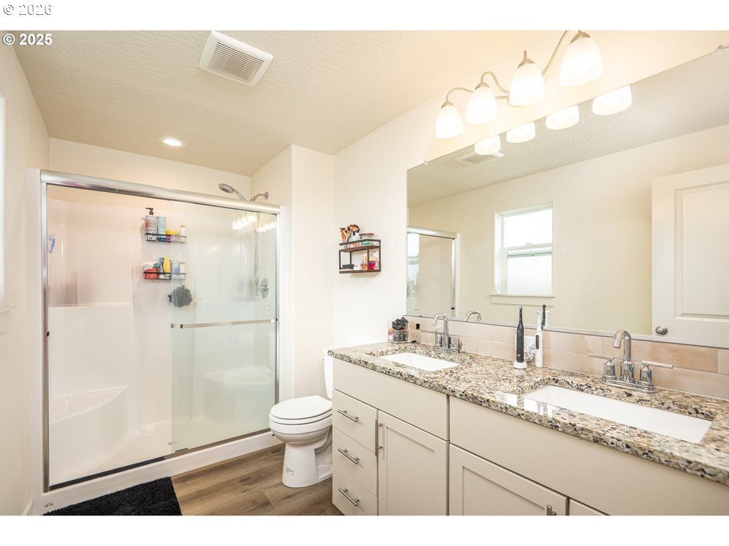 4967 Cedar View Drive Springfield, OR 97478 - Photo 12 of 22 a bathroom with a granite countertop sink a toilet a mirror a vanity and shower