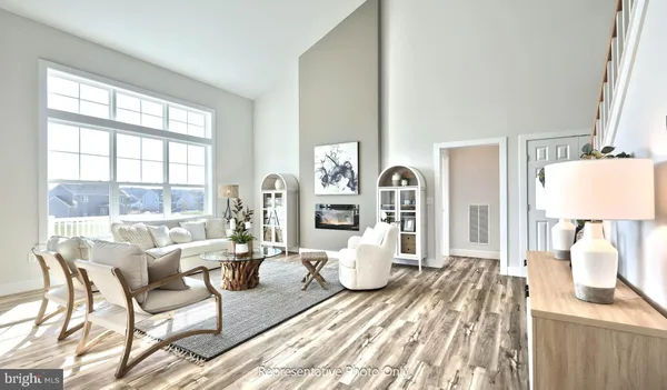 a living room with furniture a wooden floor and a large window