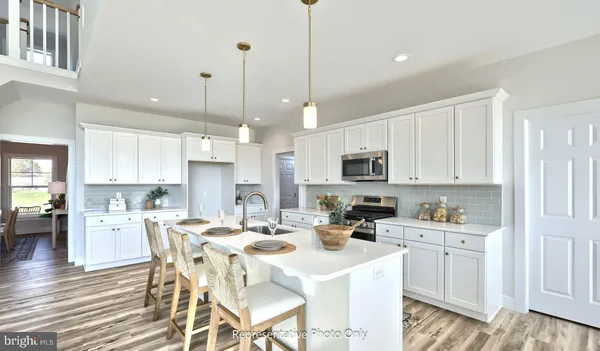 a kitchen with stainless steel appliances kitchen island granite countertop a sink a stove a dining table and chairs