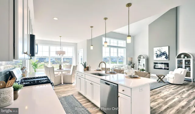 a large kitchen with kitchen island a large window a sink a center island and living room view