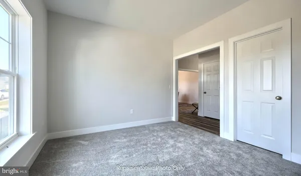 an empty room with windows and closet