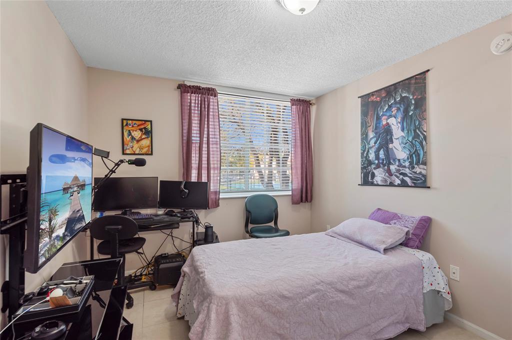 2133 Renaissance Boulevard, Unit 205 Miramar, FL 33025 - Photo 13 of 24 a bedroom with a bed and a flat screen tv