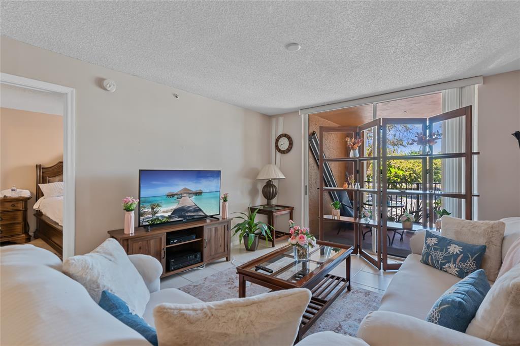 2133 Renaissance Boulevard, Unit 205 Miramar, FL 33025 - Photo 2 of 24 a living room with furniture a flat screen tv and a fireplace