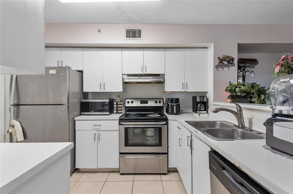2133 Renaissance Boulevard, Unit 205 Miramar, FL 33025 - Photo 5 of 24 a kitchen with a sink stove and refrigerator