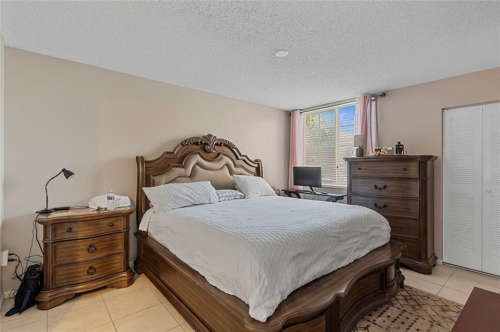 2133 Renaissance Boulevard, Unit 205 Miramar, FL 33025 - Photo 9 of 24 a bedroom with a bed and dresser