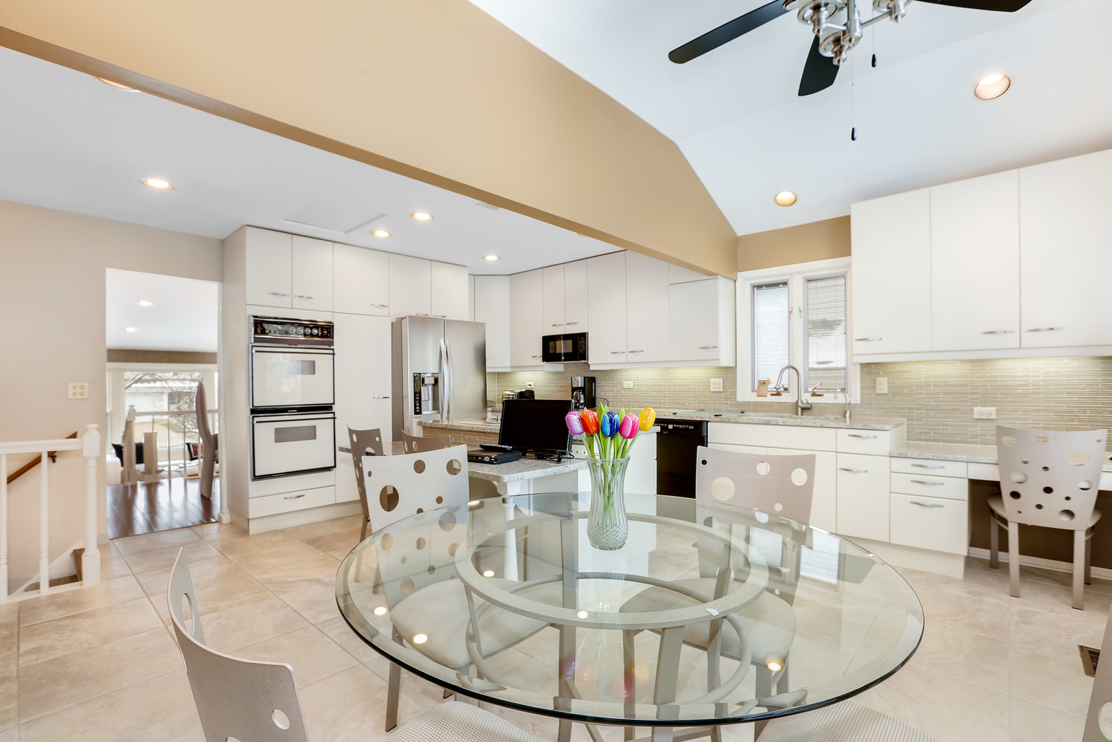 1341 Devonshire Road Buffalo Grove, IL 60089 - Photo 8 of 34 a kitchen with stainless steel appliances kitchen island granite countertop a table chairs and a refrigerator