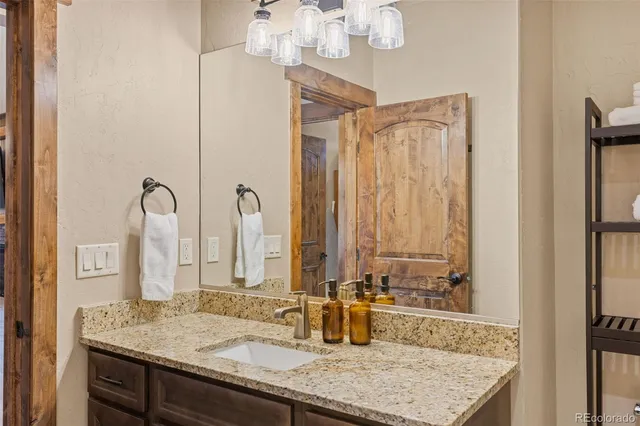 a bathroom with a granite countertop sink and a mirror