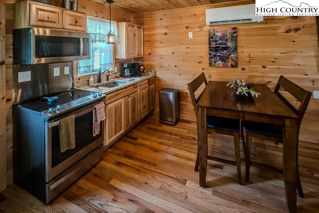 a open kitchen with stainless steel appliances granite countertop a stove and a wooden cabinets