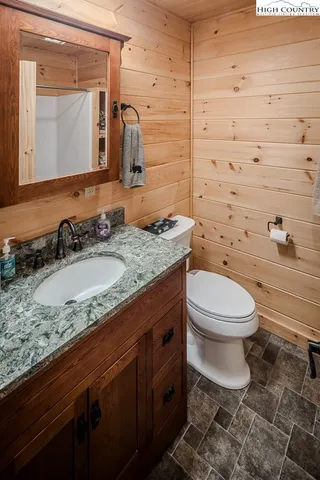 a bathroom with a granite countertop toilet sink and mirror
