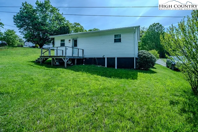 a view of a house with a yard and sitting area