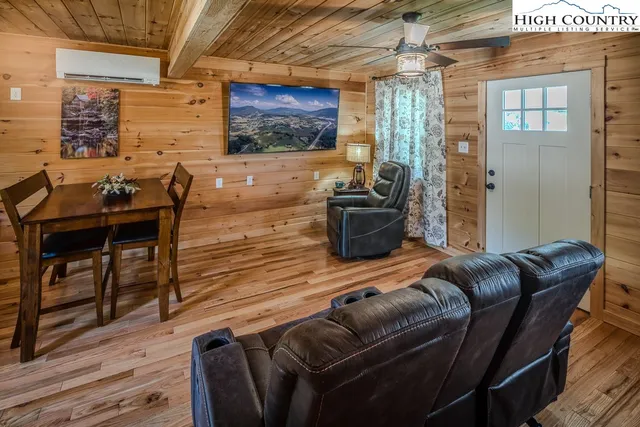 a living room with furniture a flat screen tv and wooden floor
