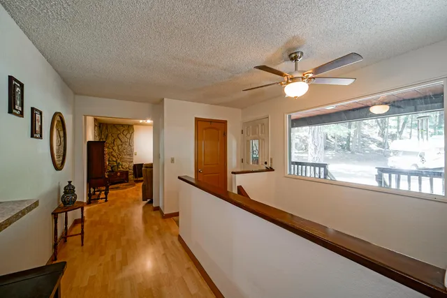 a view of a hallway with wooden floor and staircase