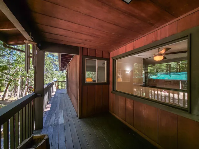 a backyard of a house with large trees and a wooden fence
